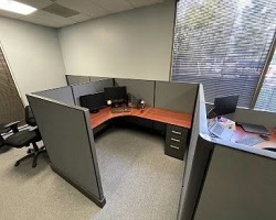 Herman Miller A02 desk with Cherrywood surfaces in an office cubicle.