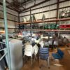Warehouse with stacked chairs and office furniture for rent.