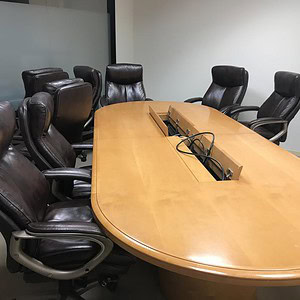 Conference table 10-foot maple with integrated power outlets for meetings and collaboration.