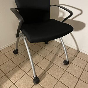 Black Haworth X99 nesting office chair with casters for mobility.