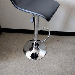 Black modern bar stool with chrome adjustable height base.