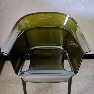 Green stackable bucket chair with modern design, perfect for contemporary interiors.