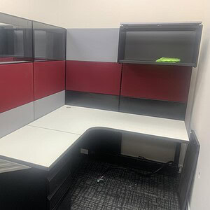 Office cubicle with glass panels and red, gray, black accents, designed for modern workspace efficie.