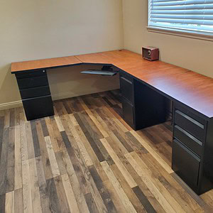Shaped mahogany desk with black legs, perfect for home or office workspace.