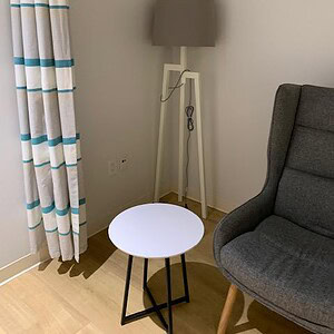 Modern white side table with black X base for living room decor and functionality.