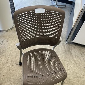 Human-scale neutral stacking chair with casters, ergonomic design, ideal for office or conference ro.