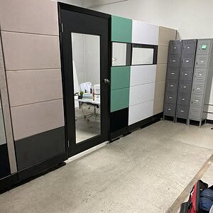 Cube wall featuring glass doors, colorful panels, and lockers in a commercial space.