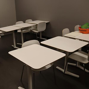 Dual white break room tables for employee lunch areas.