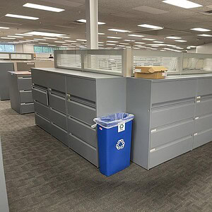 Grey Teknion lateral file cabinet with four drawers, ideal for office storage solutions.