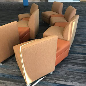 Modular sofa chairs and ottomans in neutral tones for versatile living room seating.