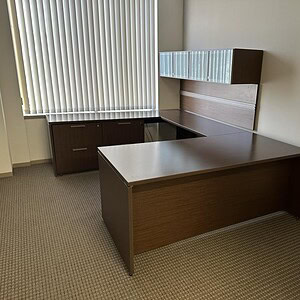 Office desk with glass hutch for modern workspace setup.