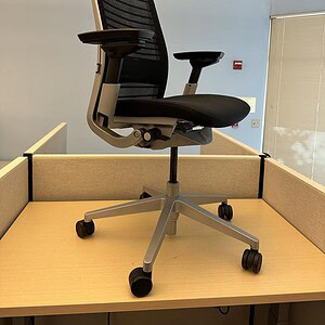 Office ergonomic chair with black mesh back and silver frame.