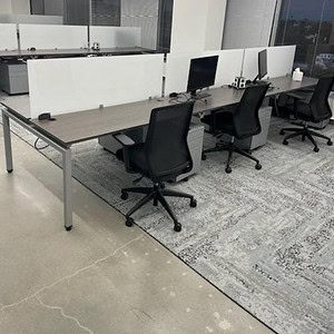 Workstation with partition panels and office chairs in modern workspace.