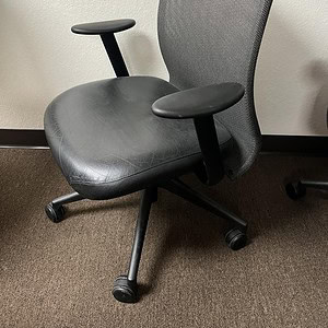 Modern ergonomic office chair with leather seat and mesh backrest.