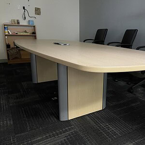 Maple conference table with integrated power outlets in a professional office setting.