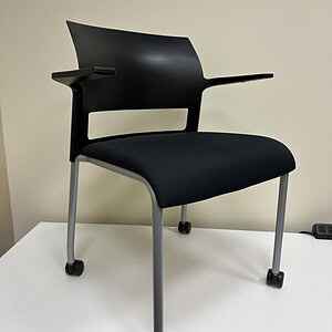 Black Steelcase Cobi stacking chair with casters for versatile office seating.