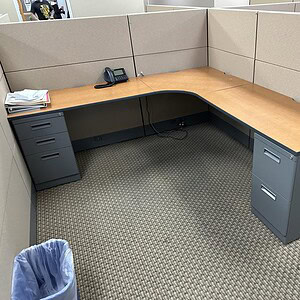Modern Ethospace cubicle desk with wood finish and gray panels in office space.