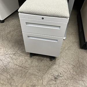 Mobile Pedestal with White Base and Neutral Cushion for Office Storage.