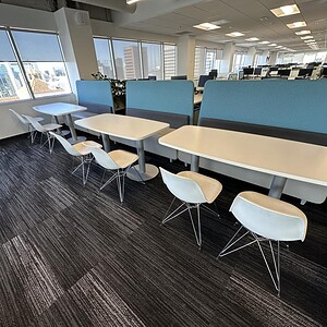 Eames Vitra Eiffel Wire Base chairs in a modern office space with large windows and city views.
