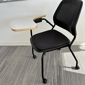 Black Allsteel tablet arm chair with stackable casters for office or conference room use.