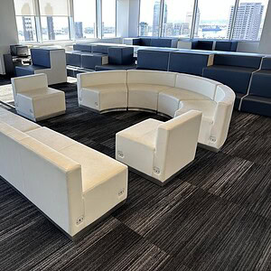 Modern white leather lounge set with curved and straight seating for office or lounge areas.