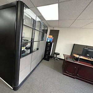 Herman Miller Ethospace black partition with glass panels in office setting.