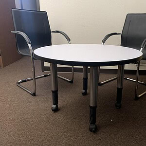 Steelcase round height adjustable table for versatile workspace solutions.