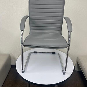 Grey vinyl side chair with chrome frame, ergonomic design, ideal for office or conference room seati.