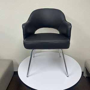Modern black vinyl guest chair with chrome legs for office or reception areas.