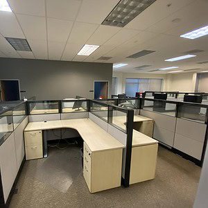 Modern office cubicles with glass partitions in Herman Miller Ethospace style.