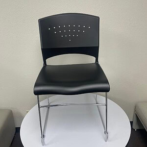 Black stack chair with chrome frame, ideal for office or conference rooms. Durable, stylish seating.