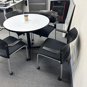 Herman Miller 3' round table with black and white finish in office setting.