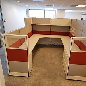 Modern office cubicle with glass panels and red-grey color accents for professional workspace design.