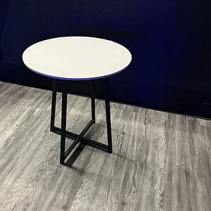 Elegant side table with black steel base and white top, ideal for modern office or lounge spaces.