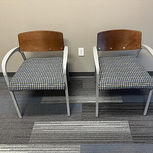 Elegant guest chairs with wood veneer and fabric upholstery for office reception areas.