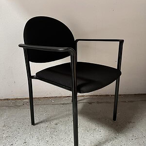 Black stacking chair with metal frame and armrests, ideal for office or conference room settings.