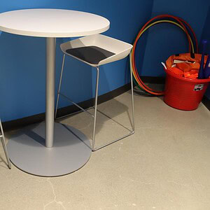 Modern Steelcase 30" round white bar height table with two stylish chairs in a contemporary setting.