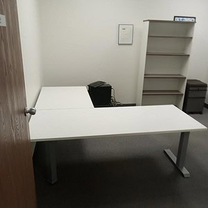 Electric HAT workstation with L-shaped desk and storage shelves.