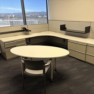 Modern office workspace with large windows and ergonomic furniture.