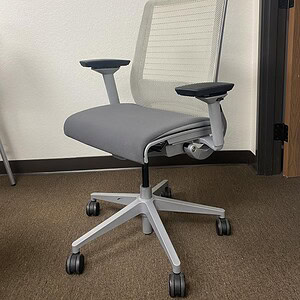 Office chair with white frame, grey seat, and mesh backrest for ergonomic comfort.