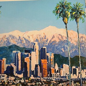 LA skyline with palm trees and mountains in the background.