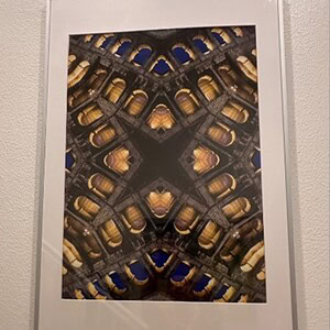 Abstract geometrical art print with symmetrical patterns in gold, black, and blue tones.