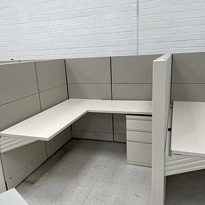 Modern white and grey Ethospace office cubicle with privacy panel.