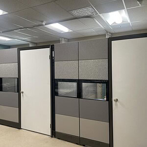 Modern Herman Miller Ethospace grey cubicles with glass panels for office privacy.