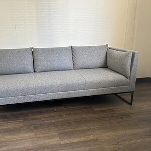 Grey sofa with steel base, mid-century design, perfect for contemporary office or living space.