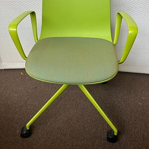 Green guest chair with armrests for conference or meeting spaces.