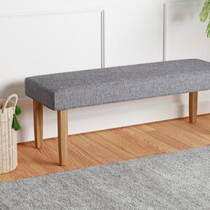 Grey linen bench with wooden legs for elegant entryway or living room seating.