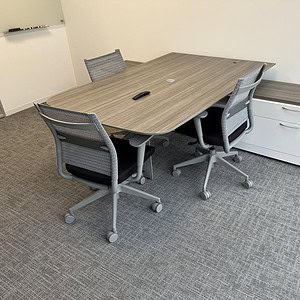 Modern 7ft trapezoid desk with driftwood finish and cantilever design for office spaces.
