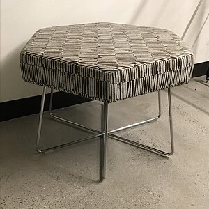 Modern Bonehexagon ottoman with wire metal base, stylish and versatile.