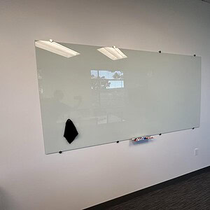 Large glass magnetic whiteboard for office or classroom use.